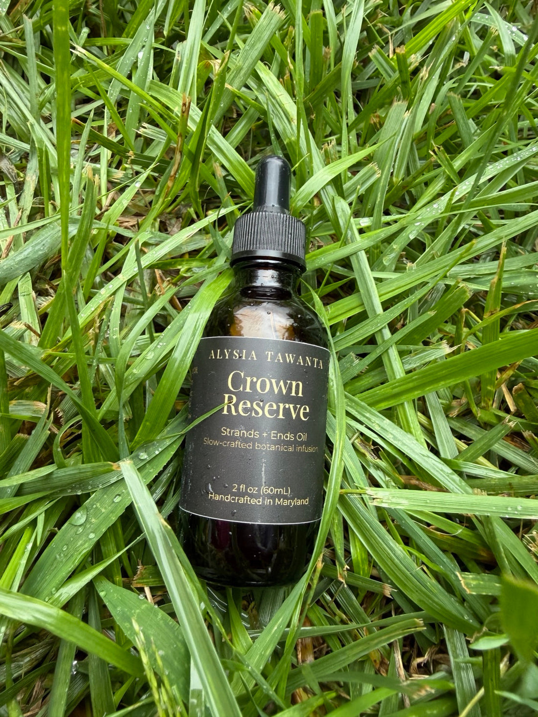 Crown Reserve Strands + Ends Oil bottle in the grass, used for a warm pre wash oil treatment